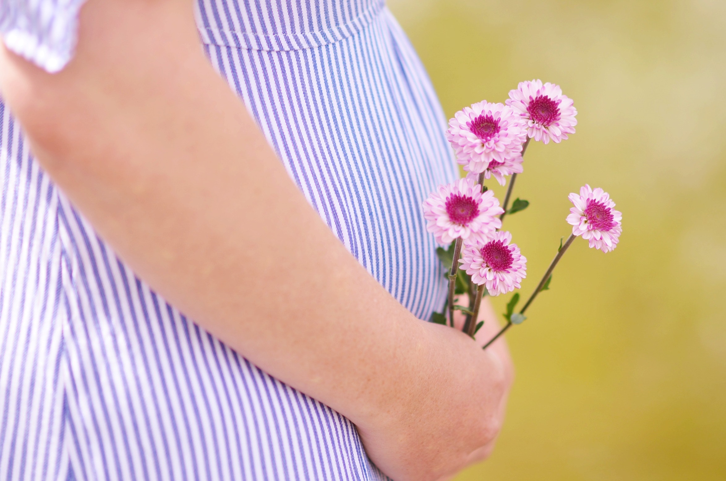 Schwangere Frau hält die Hände an ihren Bauch